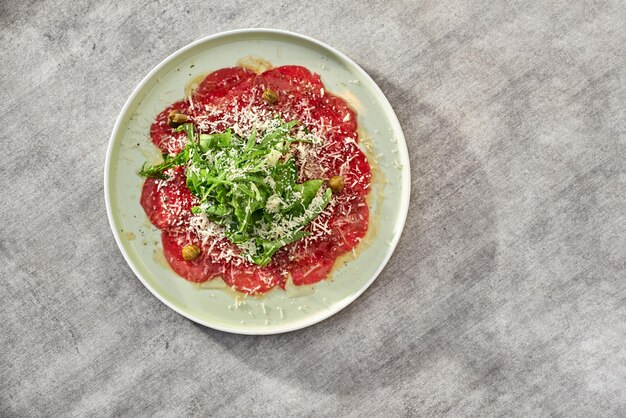 Carpaccio de bœuf marbré aux câpres de roquette et parmesan