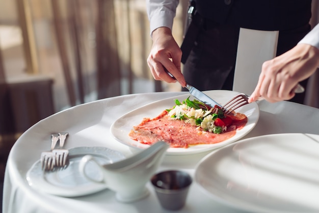 Carpaccio de boeuf rouge dans une assiette blanche