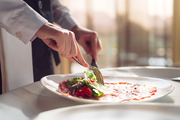 Carpaccio de boeuf rouge dans une assiette blanche