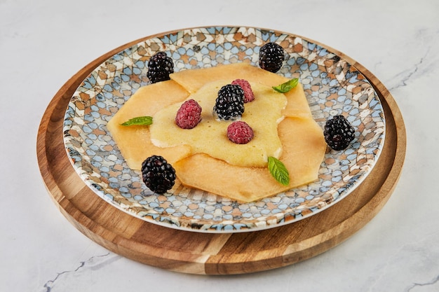 Carpaccio de melon aux framboises fraîches et mûres à bord