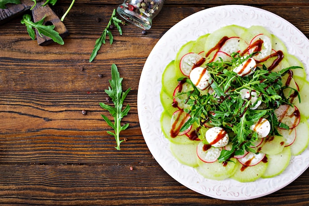 Carpaccio de radis avec roquette, mozzarella et sauce balsamique. Nourriture saine. Salade Daikon. Mise à plat. Vue de dessus