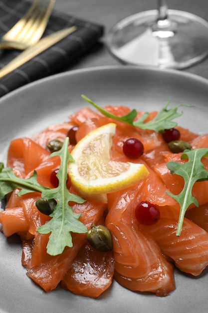 Carpaccio de saumon aux câpres canneberges roquette et citron sur gros plan de plaque