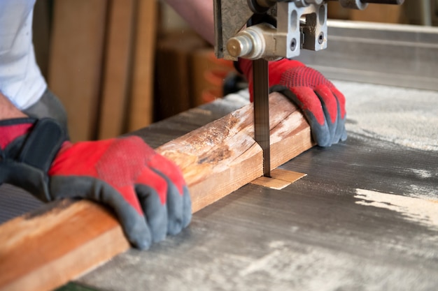 Photo carpenter couper du bois sur une scie à ruban