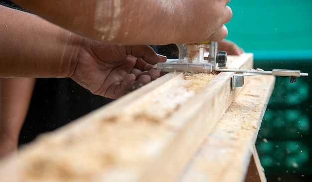 Carpenter tranche de bois dans des meubles artisanaux avec machine en atelier