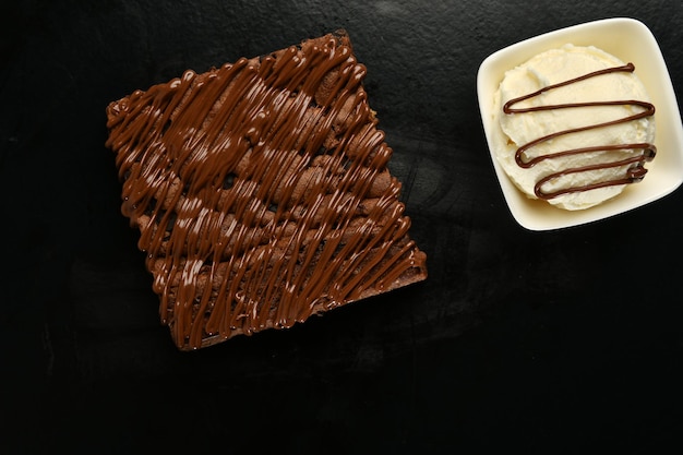 Photo un carré de chocolat avec un bol de glace à la vanille.