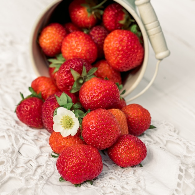 Carré. Fraises sur un vieux fond en bois blanc, serviette en tricot