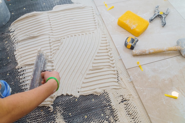 Carreaux de céramique et outils pour carreleur. Installation de carreaux de sol. Amélioration de l&#39;habitat, rénovation