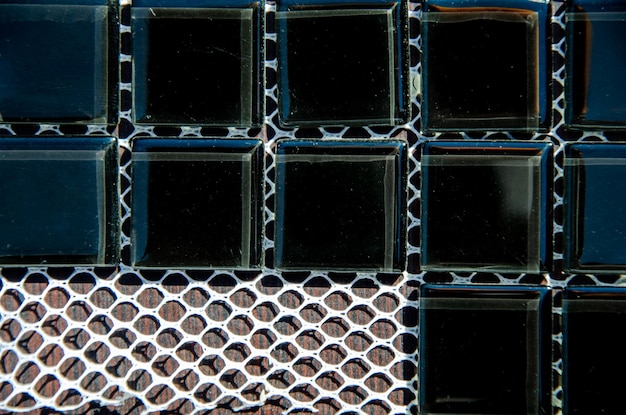 Carreaux de verre noir pour la créativité Texture de carreaux carrés de mosaïque décorative sur support en maille gros plan