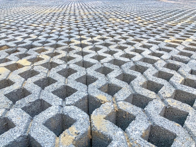 Carrelage de sol en briques de pierre de couleur grise avec de l'herbe verte et du sable comme arrière-plan ou texture