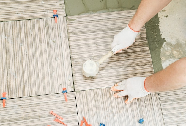 Carreleur Utilisant Un Marteau En Caoutchouc Pour Aligner Les Carreaux De Céramique