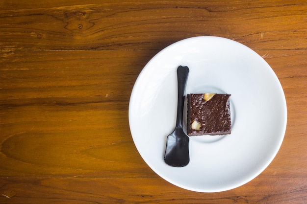 Carrés de brownie aux pépites de chocolat et noix sur table en bois