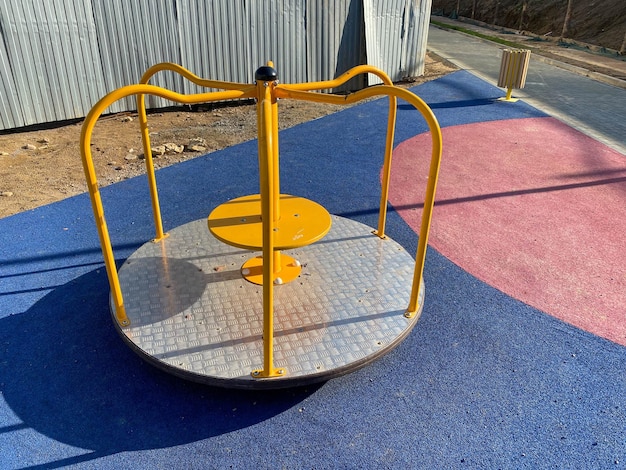 Carrousel balançoire bleu métal rond pour enfants pour jeux de sport dans la cour d'un nouveau bâtiment