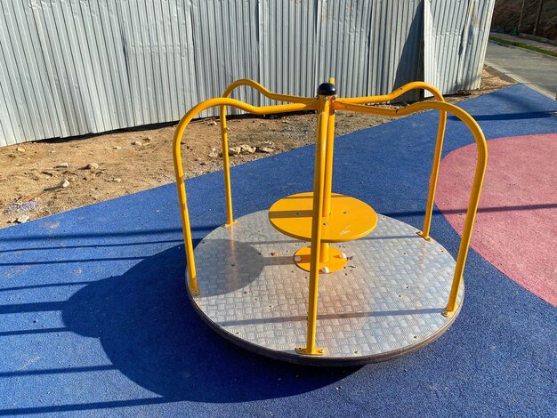 Carrousel balançoire bleu métal rond pour enfants pour jeux de sport dans la cour d'un nouveau bâtiment