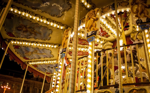 Carrousel pour enfants dans un parc d'attractions dans l'éclairage nocturne Détail du carrousel rétro