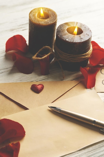 Carte-cadeau pour la Saint-Valentin avec stylo et bougies sur fond de bois blanc