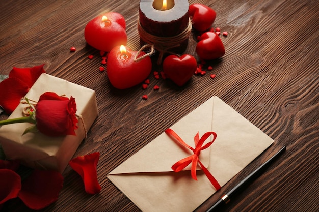 Carte-cadeau pour la Saint-Valentin avec stylo et bougies sur fond de bois