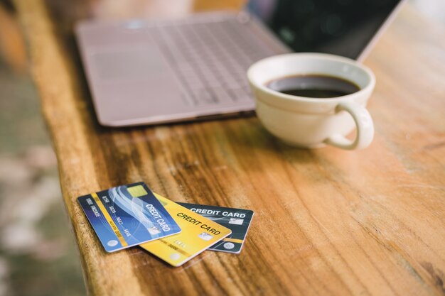 Photo carte de crédit sur ordinateur portable avec café, en plein air