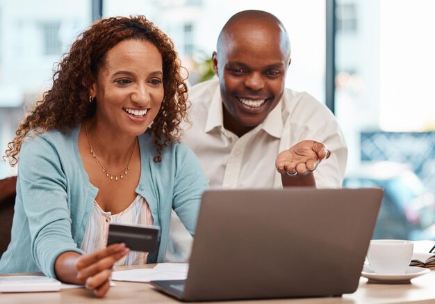 Photo carte de crédit pour ordinateur portable et achats en ligne de couple dans le paiement à domicile ou la banque numérique ordinateur de commerce électronique et homme noir heureux et femme mûre avec des ventes fintech ou un achat interracial sur une boutique en ligne