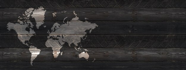 Carte du monde isolée sur fond de mur en bois noir.