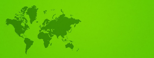 Carte du monde isolée sur fond de mur vert.