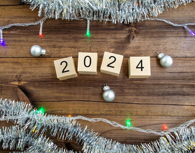 Carte du Nouvel An 2024 Cubes en bois avec chiffres Guirlande de guirlandes 2024 et boules du Nouvel An