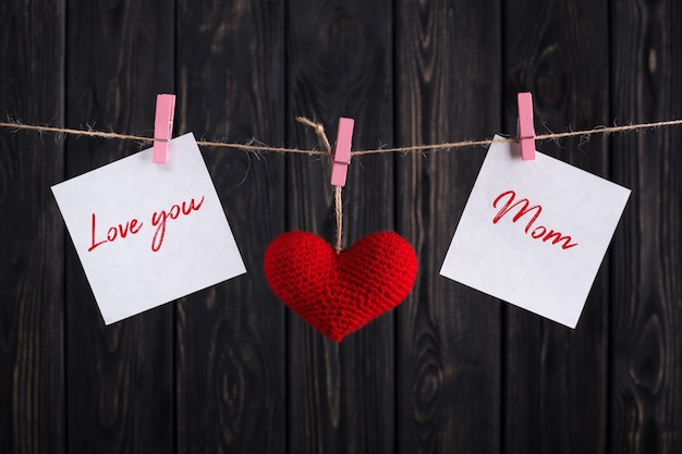 Carte de fête des mères avec coeur rouge et autocollants en papier sur corde