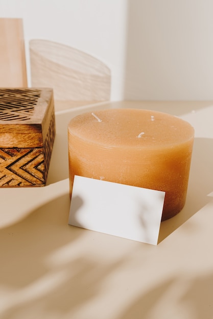 Carte de feuille de papier vierge avec cercueil en bois et bougie avec ombre du soleil sur beige