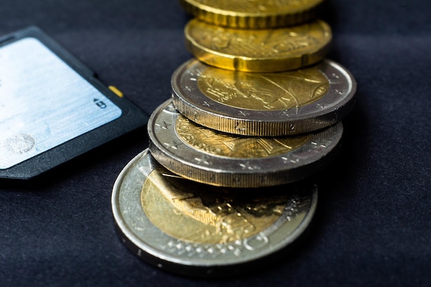 Carte flash de concept d'argent avec des pièces en euros gros plan sur fond sombre