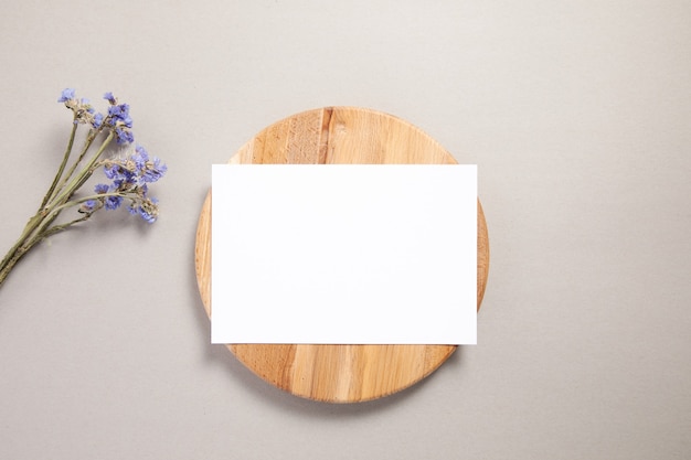 Carte d'invitation blanche sur un bois avec fleur violette