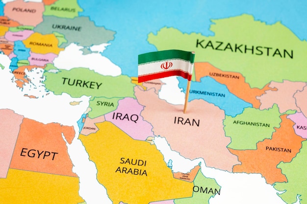 Une carte de l'Iran avec le drapeau national de l' Iran dessus Le drapeau est vert blanc et rouge tricolore Le long des bords des rayures est le Takbir et au centre est l'emblème national