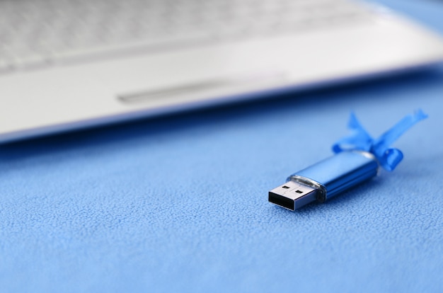 Photo carte mémoire flash usb bleu brillant avec un arc bleu se trouve sur une couverture
