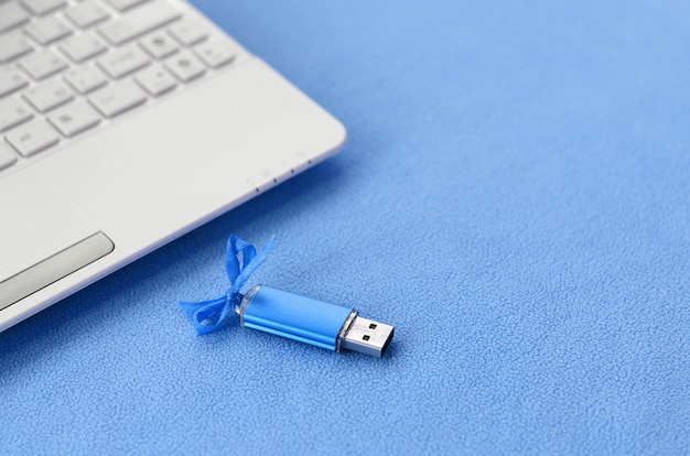 Carte mémoire flash USB bleu brillant avec un arc bleu se trouve sur une couverture