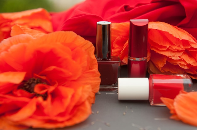 Carte de mode avec coquelicots et cosmétiques couleur rouge - vernis à ongles et rouge à lèvres