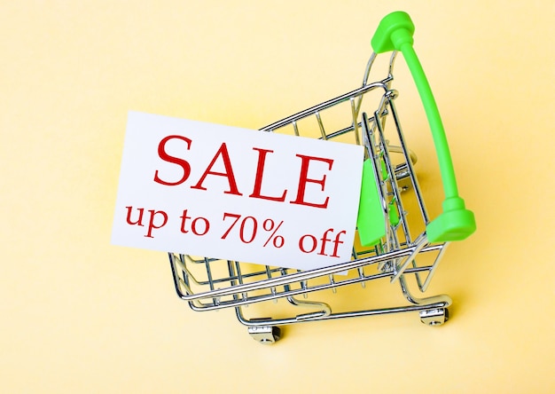 La carte avec les mots SALE JUSQU'À 70 OFF se trouve dans le panier. Concept de marketing
