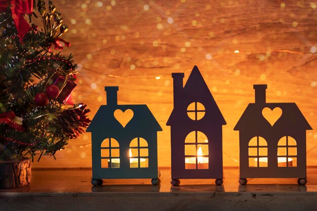Carte de Noël avec des bougies dans les chandeliers des maisons Arbre de Noël sur la cheminée