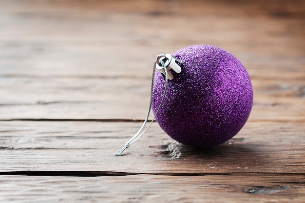 Carte de Noël avec boule violette sur la table en bois