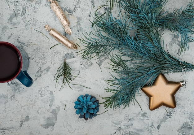 Photo carte de noël avec des branches de sapin et des jouets d'arbre de noël, thé et bonbons