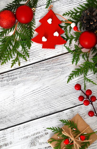 Photo carte de noël avec des branches de sapin jouets et une guirlande décor avec des bonbons à la cannelle