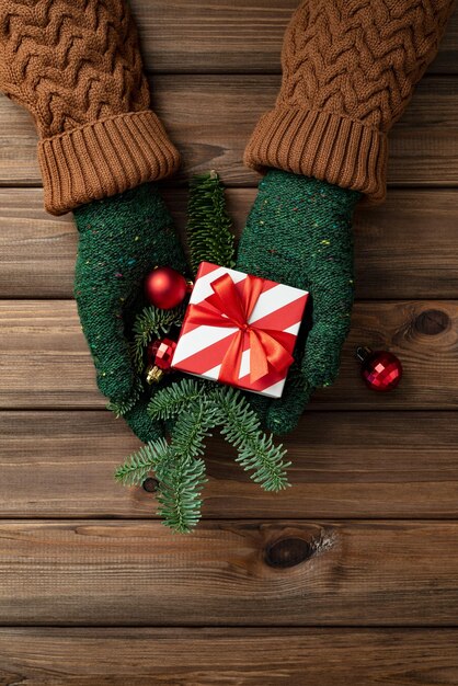 Carte de Noël avec cadeau de Noël entre les mains d'une femme