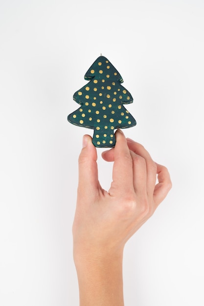 Carte de Noël minimaliste. Une femme tenant un arbre à jouets dans sa main, vue recadrée. photo de haute qualité