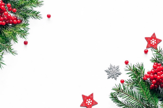 Carte de Noël et nouvel an avec des branches de sapin et décor sur fond blanc.