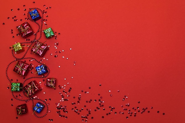 Carte de Noël avec place pour le texte. Décorations d'arbre de Noël et paillettes brillantes sur fond rouge. photo horizontale.