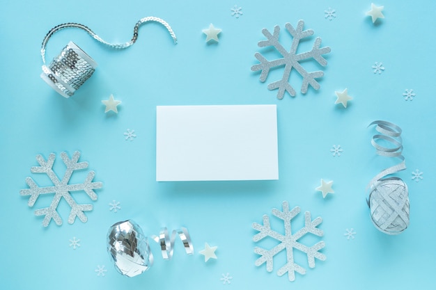 Carte de Noël vierge avec des décorations en argent sur une surface bleue