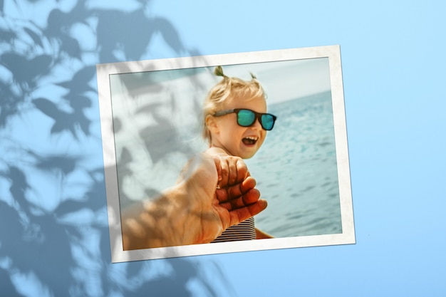 Une Carte Photo Blanche Avec Un Enfant Sur Un Mur De Couleur Bleu Safran Avec Une Ombre D'un Arbre