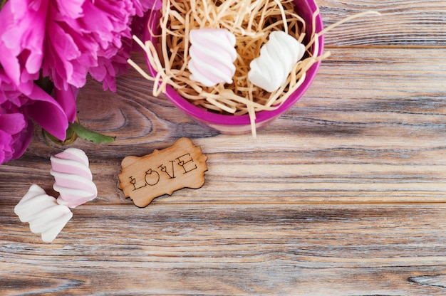 Carte postale avec des fleurs de pivoine, des bonbons