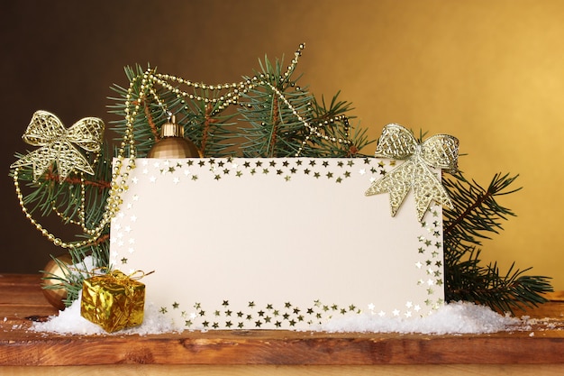 Carte postale vierge, boules de Noël et sapin sur table en bois