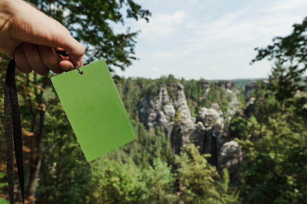 Photo carte verte dans les mains des hommes sur l'arrière-plan du parc national de la suisse saxonne, allemagne.