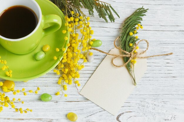 Carte vide avec mimosa, citron et café sur table en bois clair