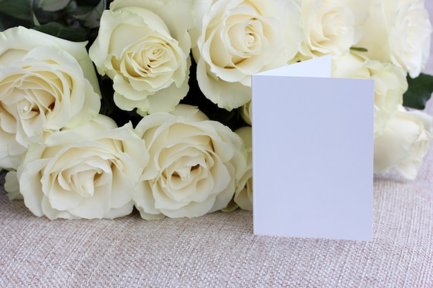 Carte vierge et bouquet de roses blanches