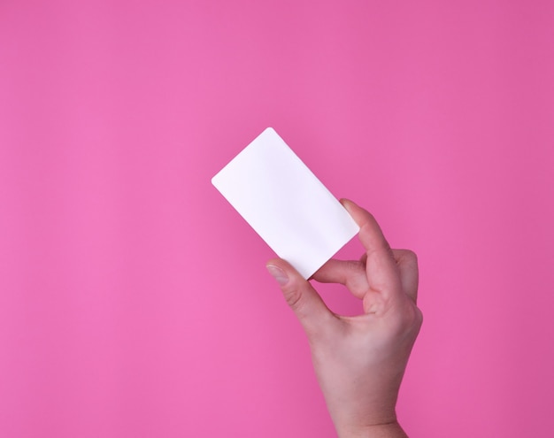 Carte de visite rectangulaire blanche vide dans une main féminine